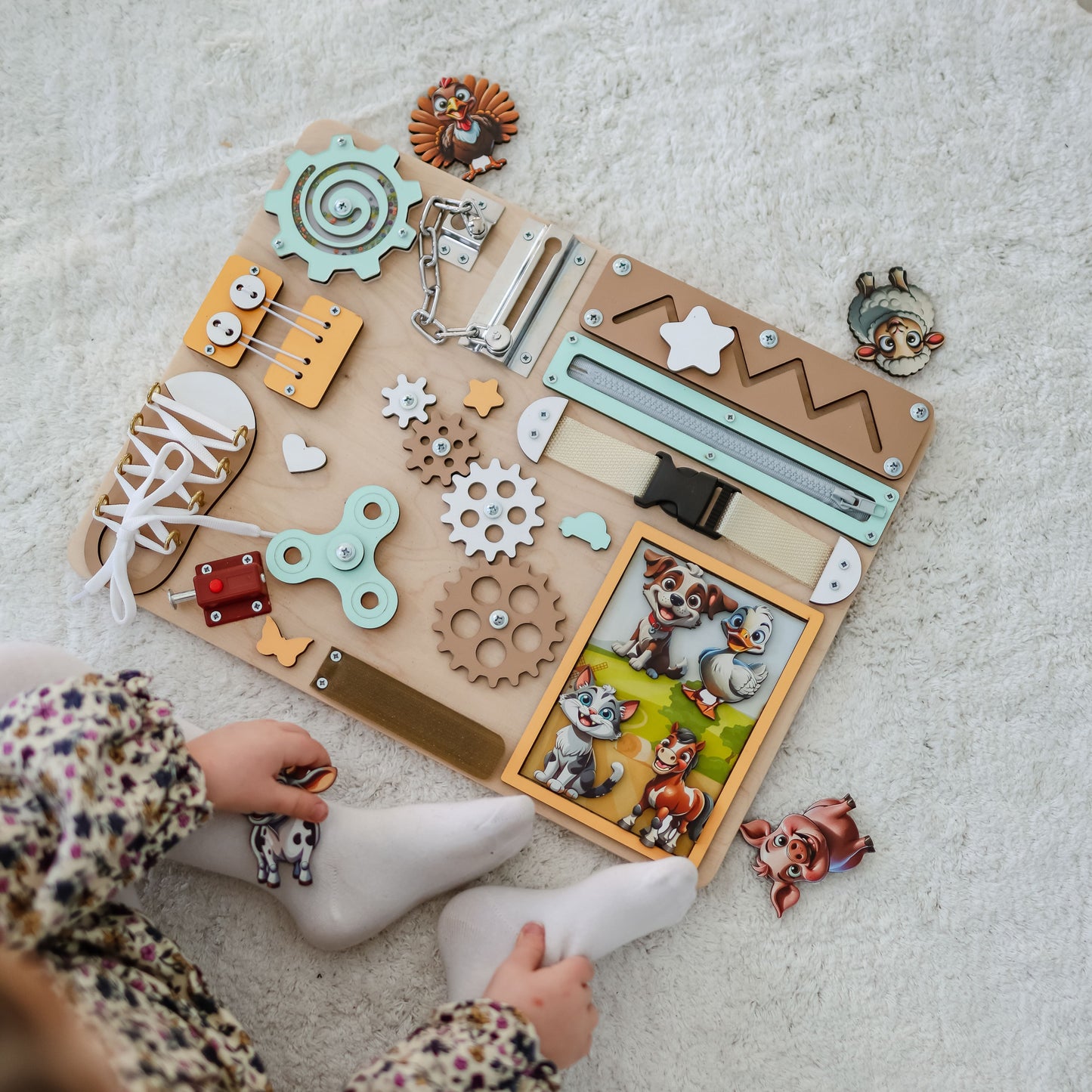 Magnetic cow and horse on an interactive wooden busy board
