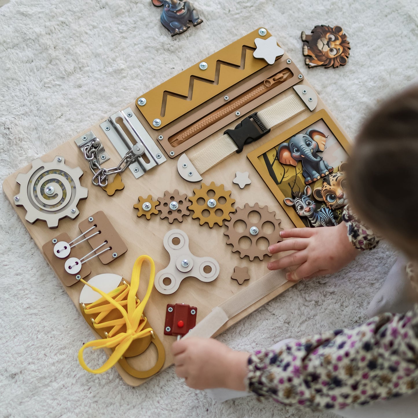 Montessori sensory play board featuring lions, giraffes, and elephants
