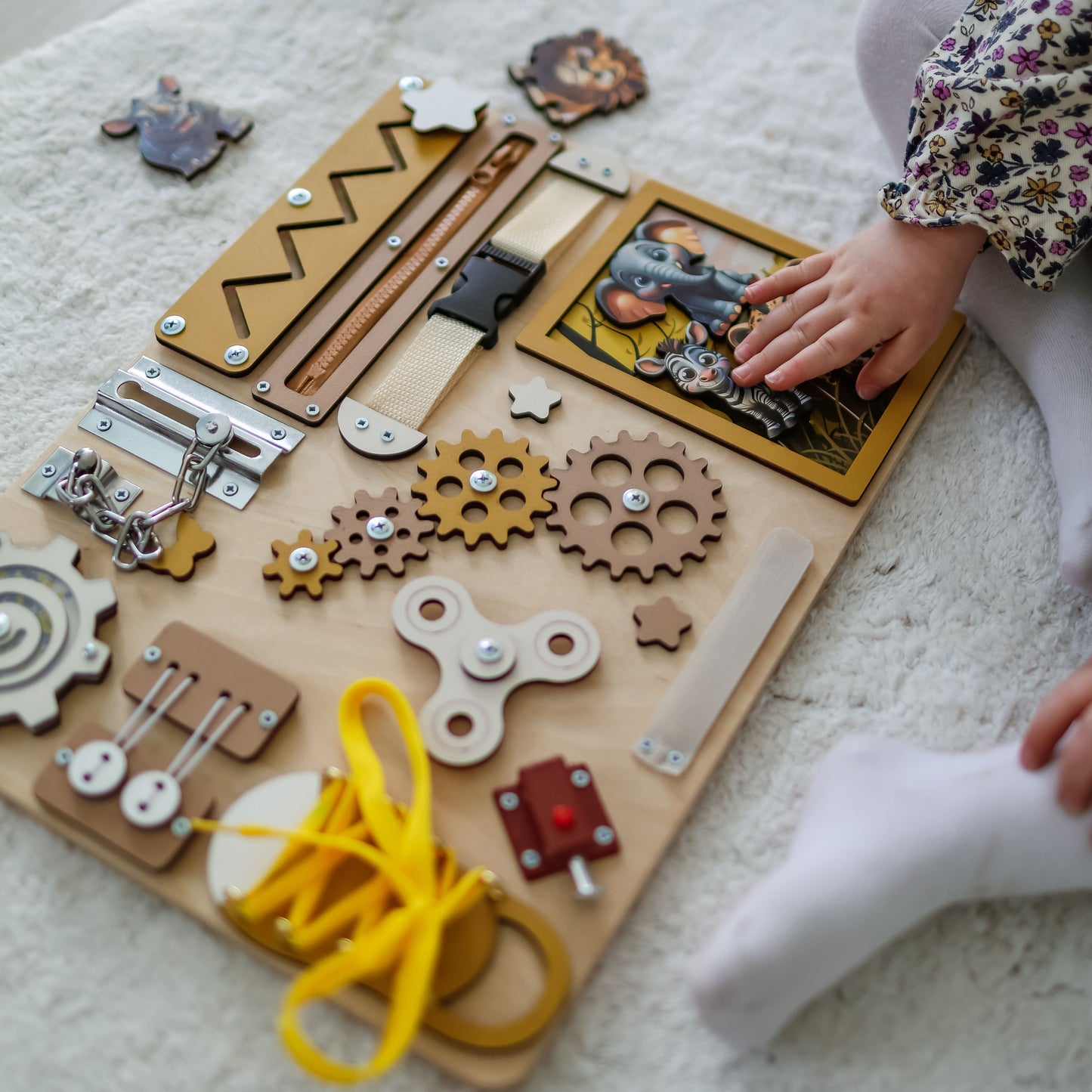 Toddler arranging magnetic safari animals on an interactive activity board