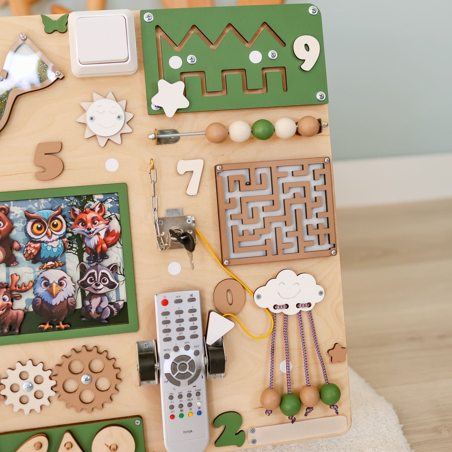 Toddler arranging magnetic animals on an oversized forest busy board