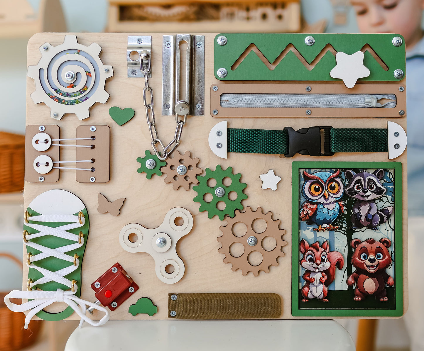 Handmade wooden busy board with a forest background and magnetic animals