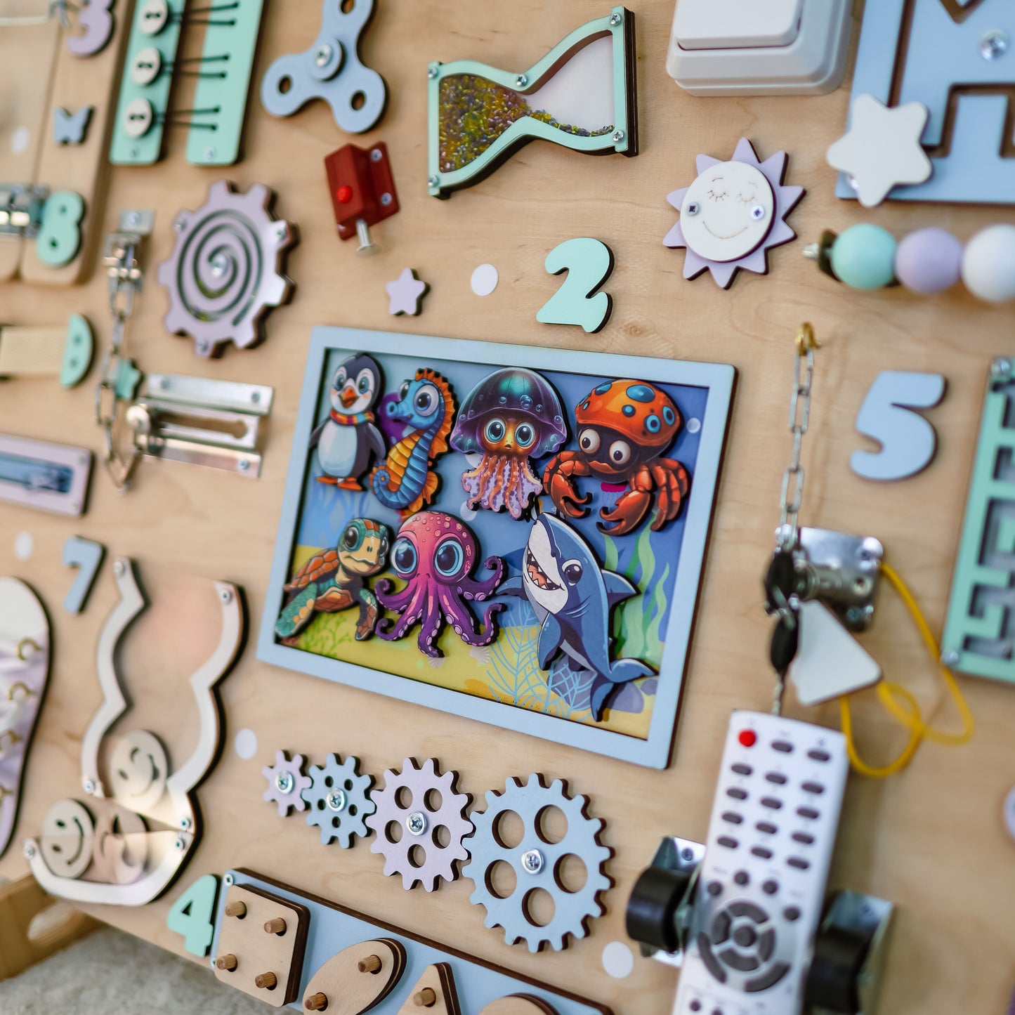 Toddler playing with an oversized Montessori underwater-themed busy board