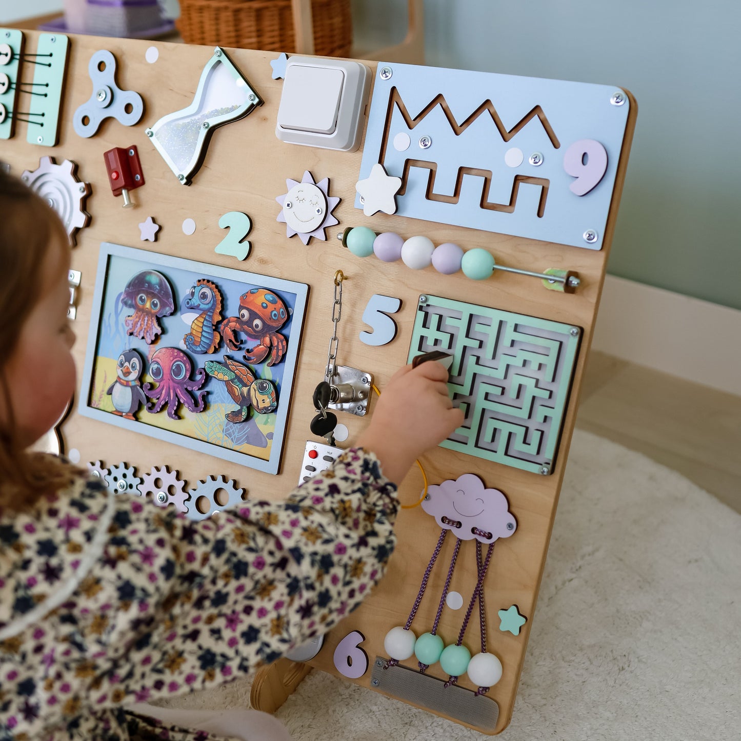 Toddler arranging magnetic sea animals on an interactive extra-large activity board