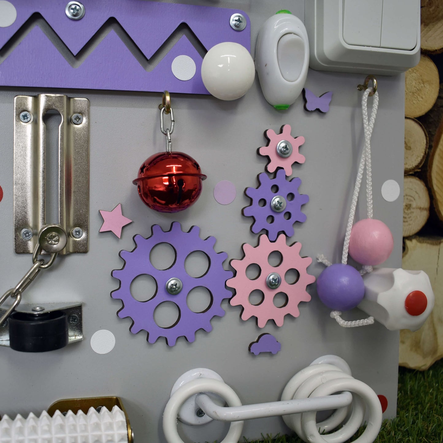 Gray toddler activity board with pink spinner and abacus