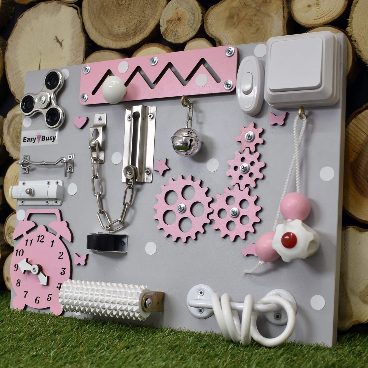 Pastel-colored toddler busy board with switch and zipper