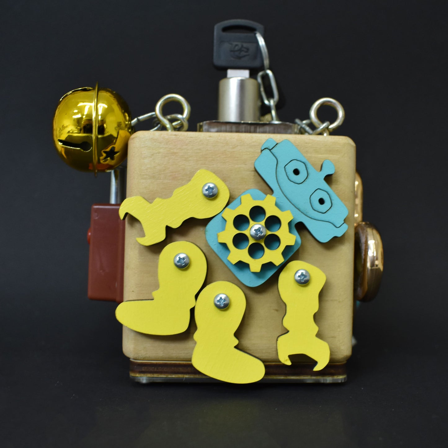 Busy cube on yellow stand with labyrinth and green fidget spinner