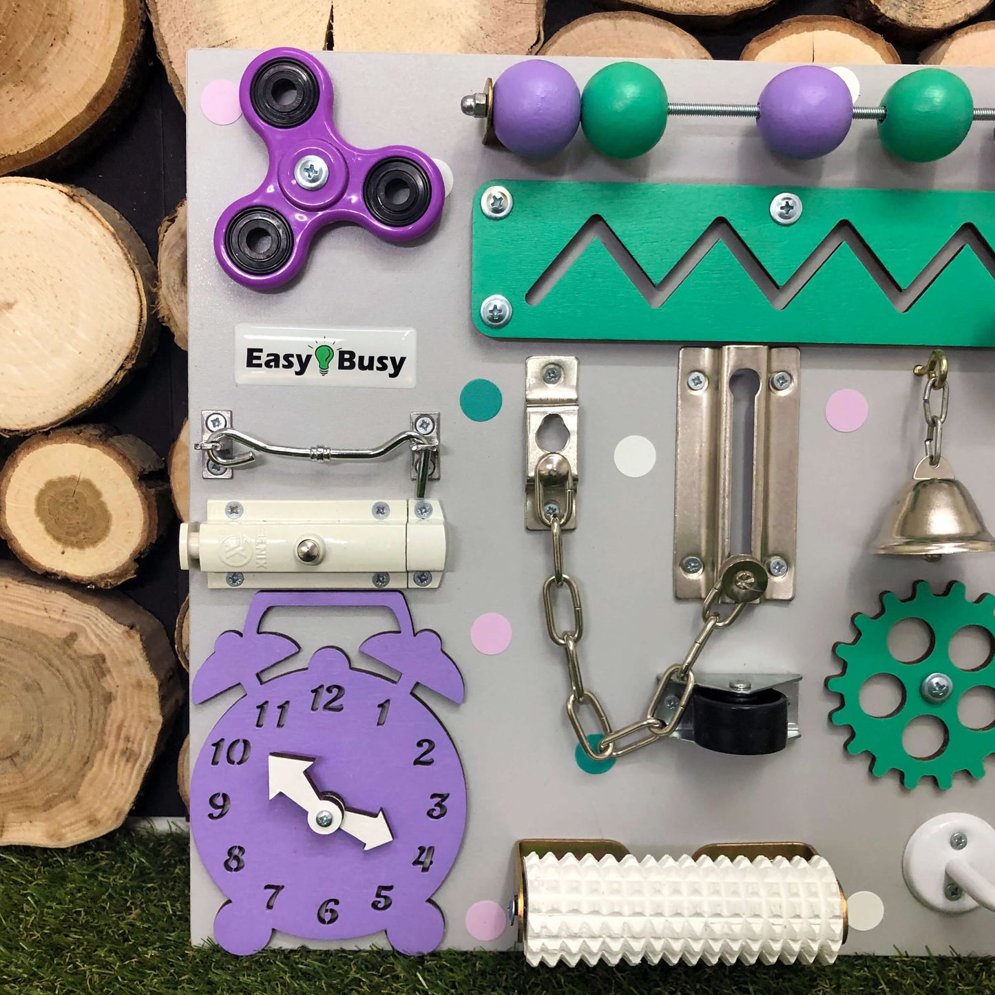 Handmade toddler busy board in soft pink and purple with interactive gears and switches