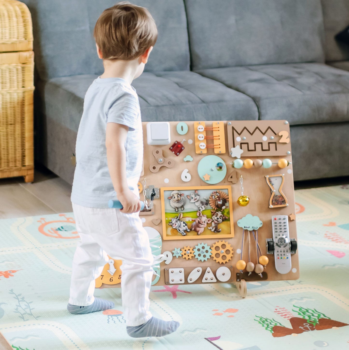 Montessori sensory play board featuring cows, sheep, and pigs