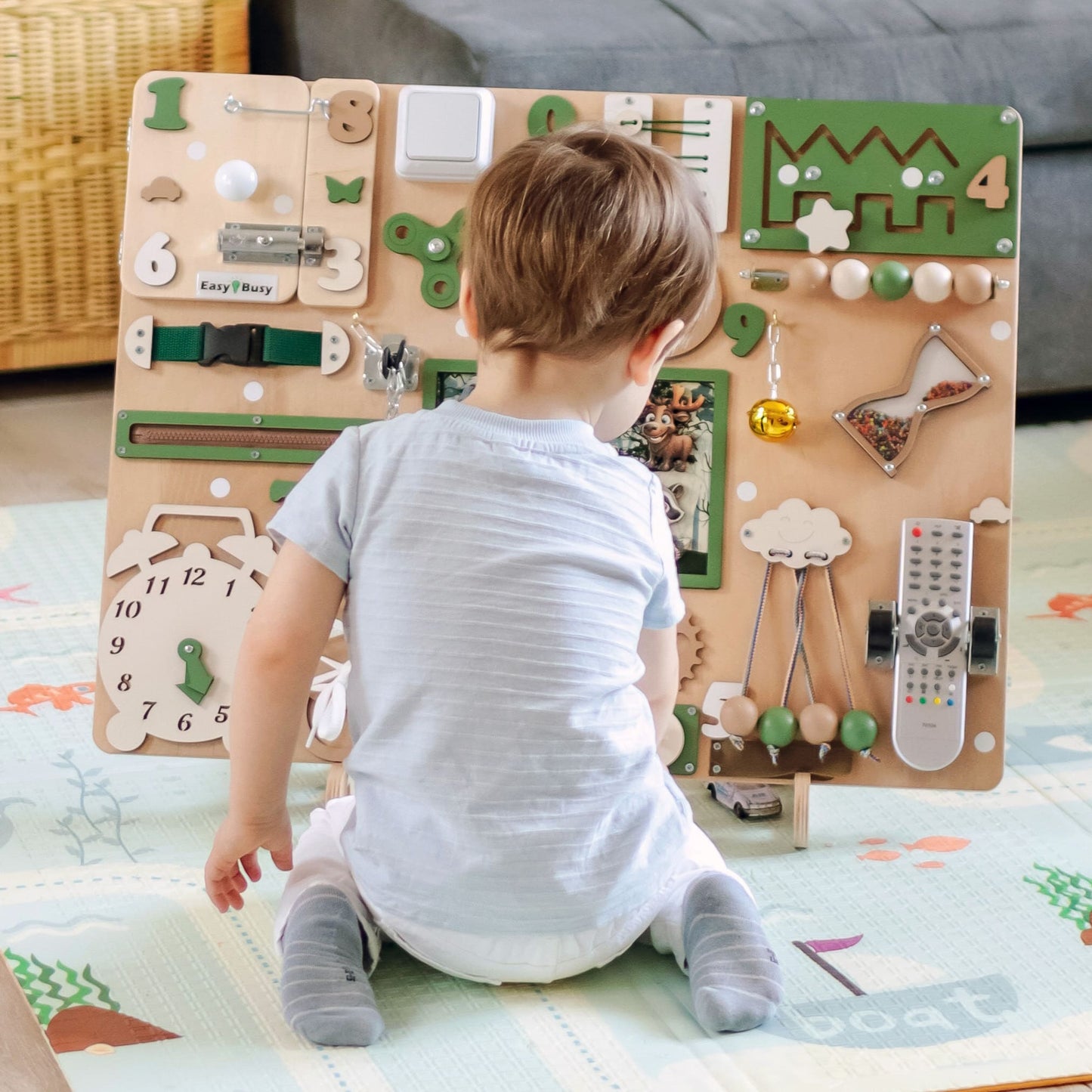 Toddler Exploring the Busy Board with Parent. A child and parent interacting with the animated busy board, engaging in sensory play, problem-solving, and early learning activities
