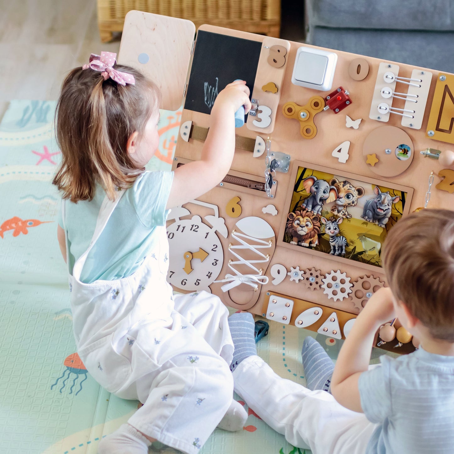 Toddler arranging magnetic jungle animals on an oversized play board
