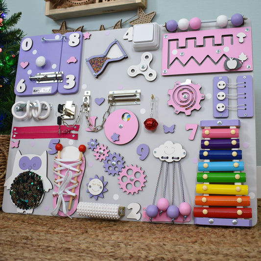 Wooden activity board for toddlers with pastel colors and musical toys