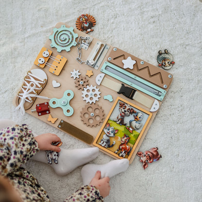 Magnetic cow and horse on an interactive wooden busy board