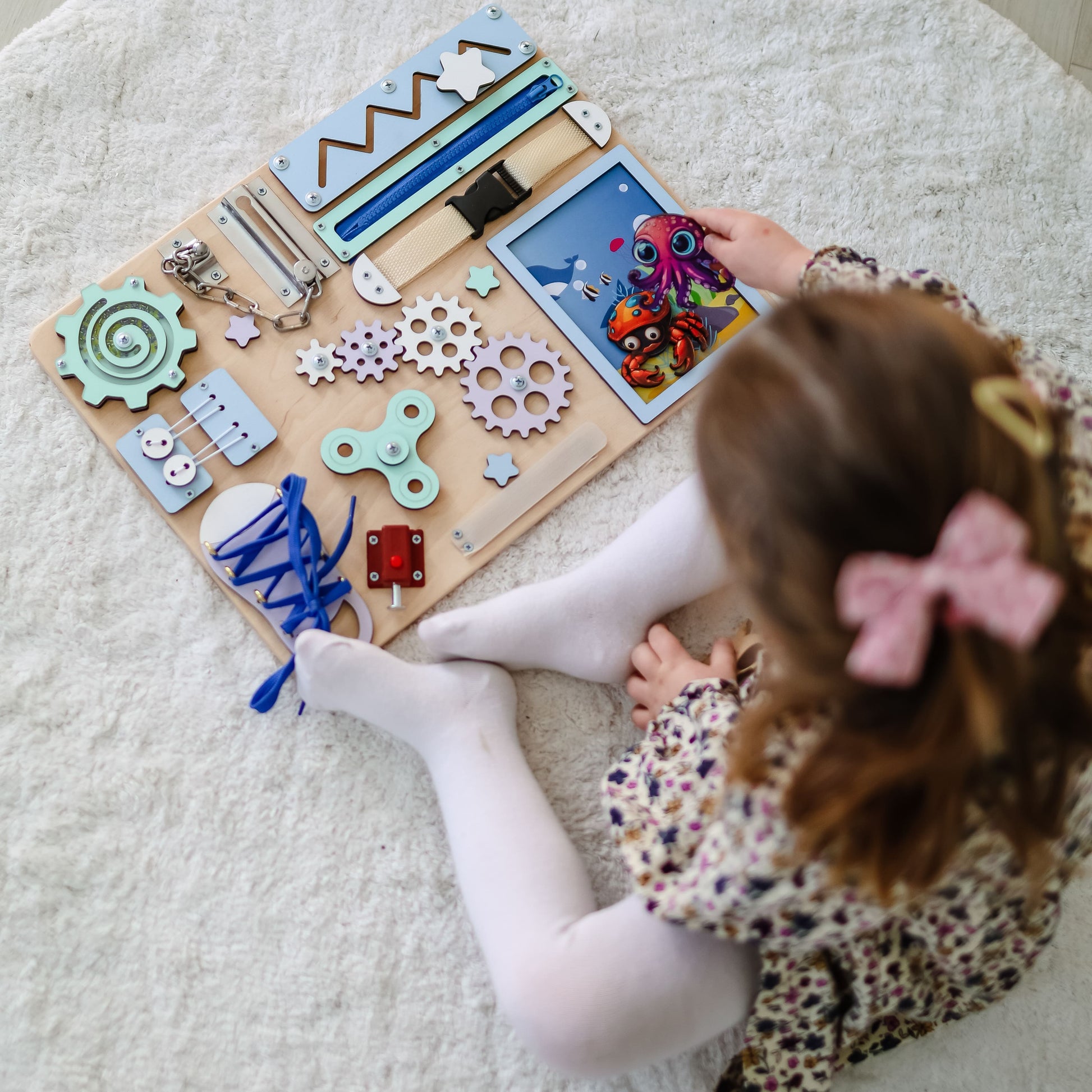 Montessori-inspired busy board featuring whales, fish, and octopuses