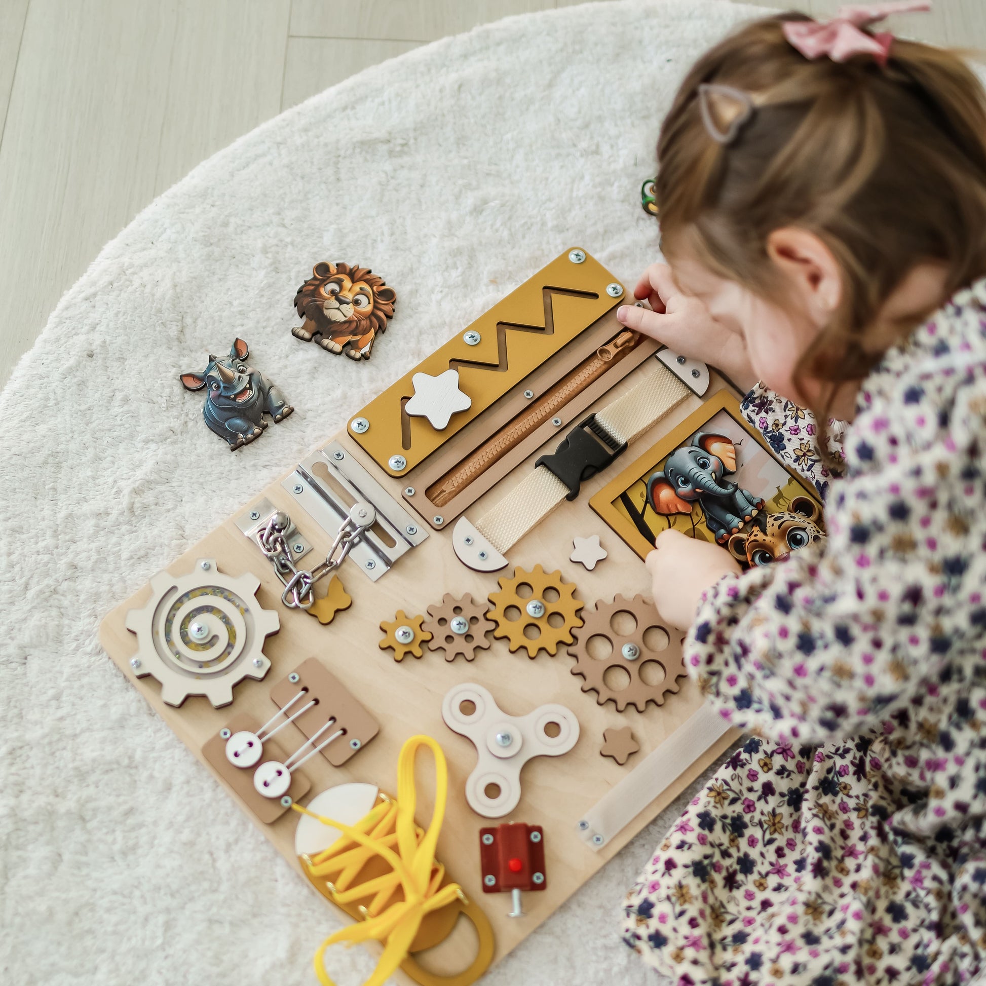 Magnetic lion and zebra on an interactive wooden busy board