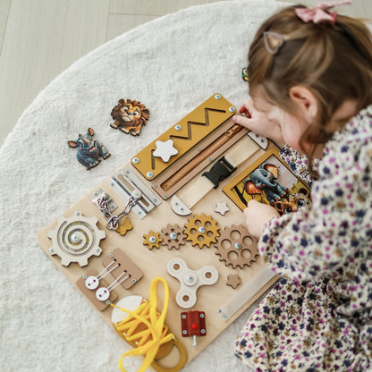 Magnetic lion and zebra on an interactive wooden busy board