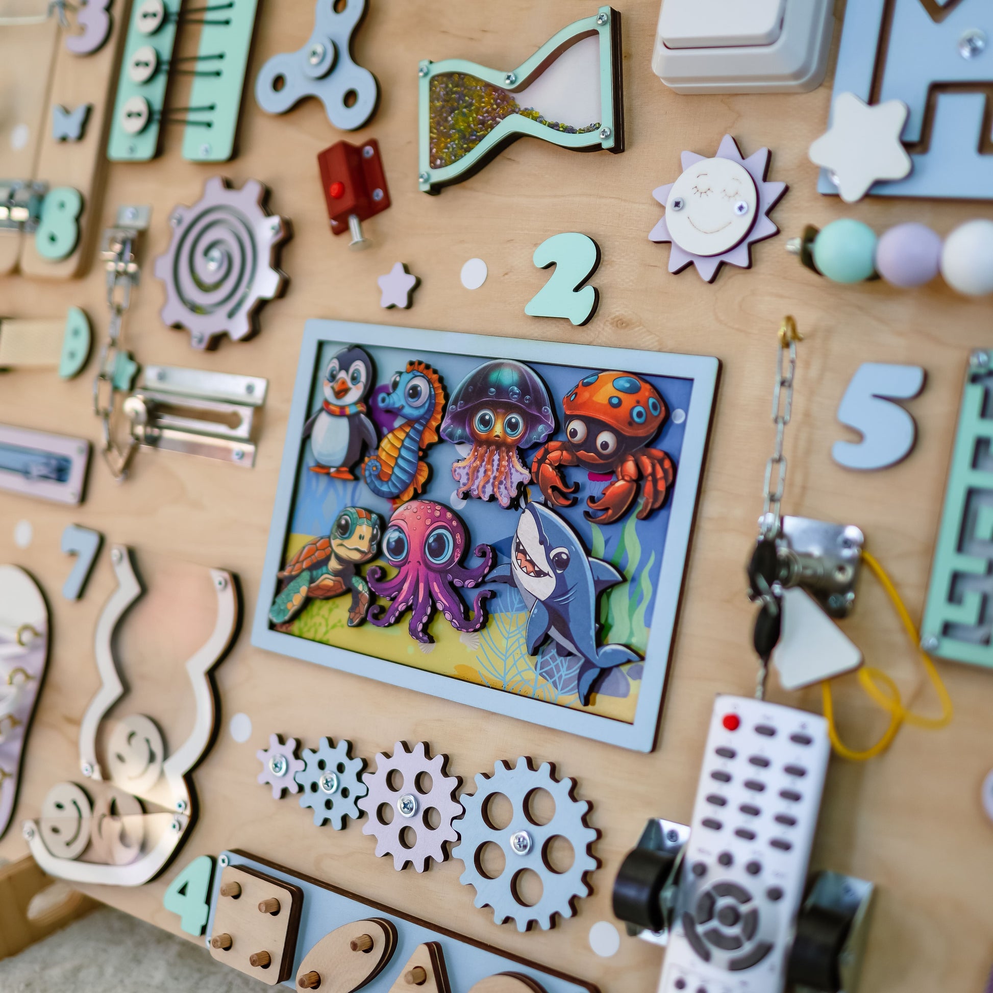 Toddler playing with an oversized Montessori underwater-themed busy board