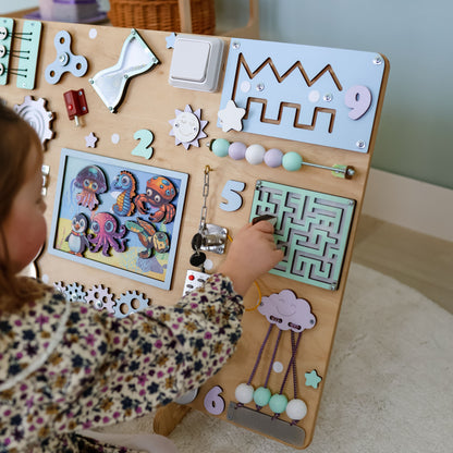 Toddler arranging magnetic sea animals on an interactive extra-large activity board