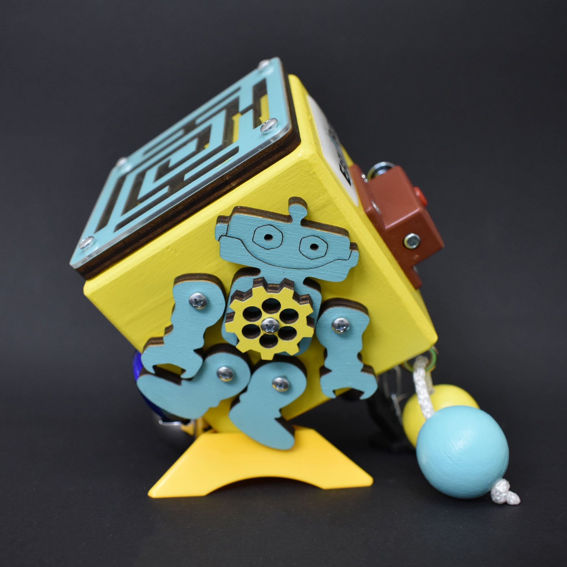 Close-up of wooden busy cube with spinning elements