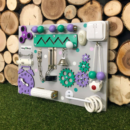 Montessori busy board with pink gears and clock on gray base for toddler fine motor skills